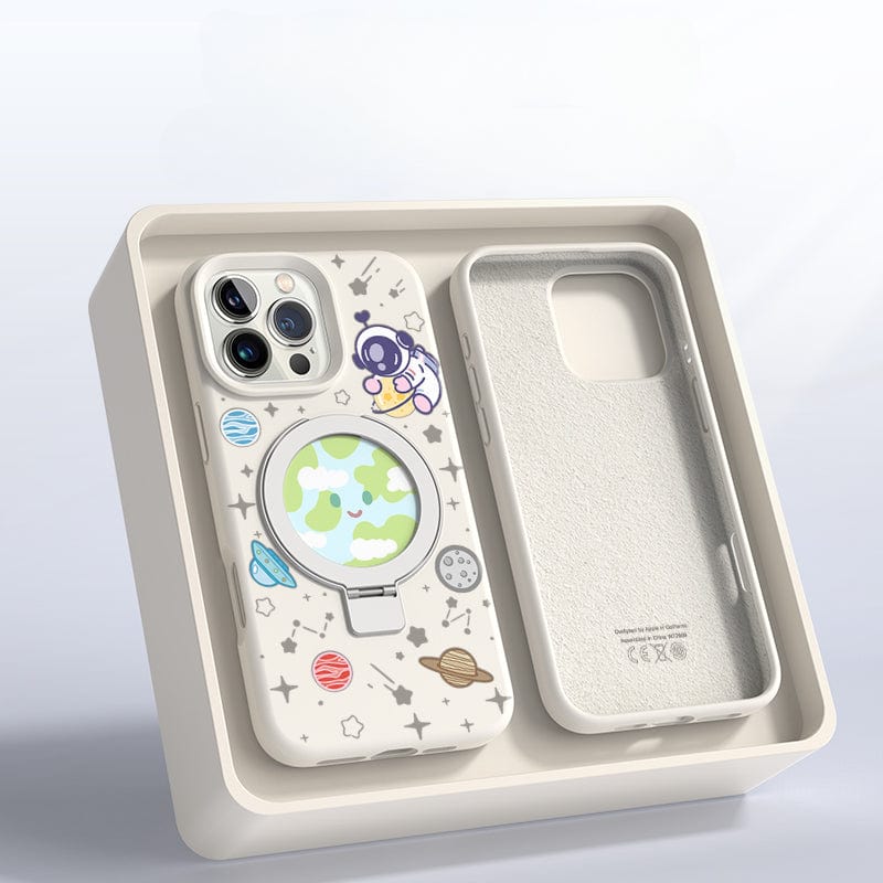 An iPhone 16 Pro Max in a Pink Silicone MagSafe Case with Stand, featuring a space theme complete with planets and stars, rests in an open beige box with an additional slot for another phone or accessory.
