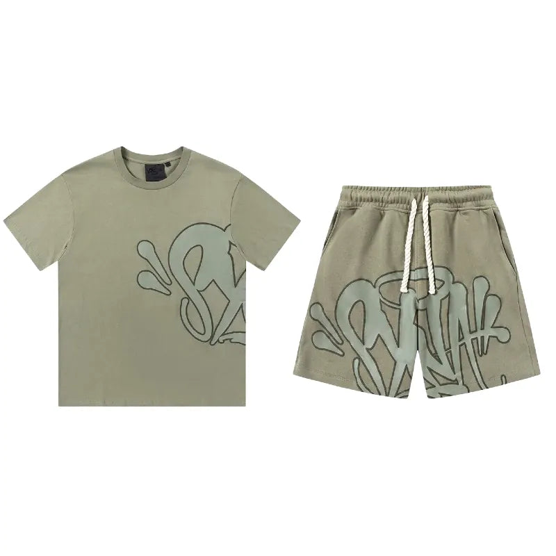 Olive green Syna World T-Shirt and Shorts Set with accessories, featuring abstract graffiti-style lettering and splash designs on both pieces. Available in 8 colors.