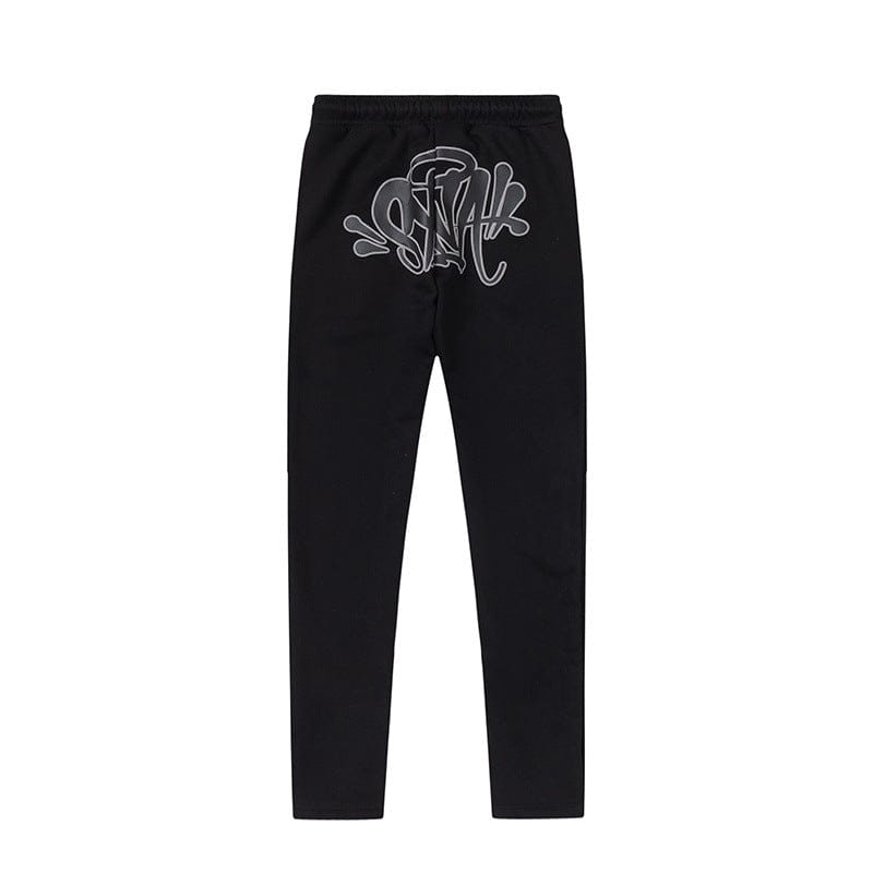 Black Syna World Matching Tracksuit Pants – Streetwear Jogger Pants in 6 colors, shown laid flat on a white background with a silver graffiti-style graphic near the waistband.