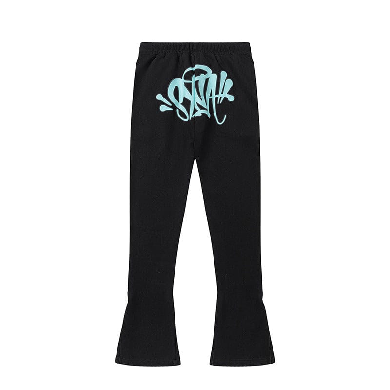 Syna World Graphic Tracksuit Pants in black feature flared legs and a light blue graffiti-style text graphic on the back waistband—perfect for bold streetwear fans. Available as matching pants in 4 colorways.