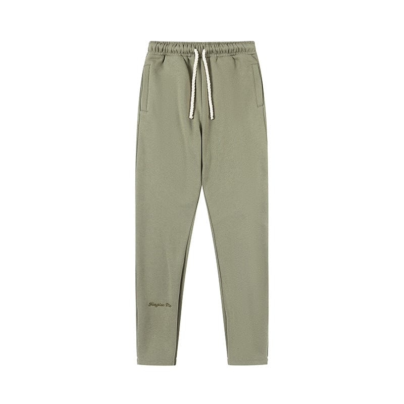 Syna World Matching Tracksuit Pants – Streetwear Jogger Pants in light olive green with elastic waistband, white drawstring, side pockets, and subtle left leg text. Available in 6 colors.