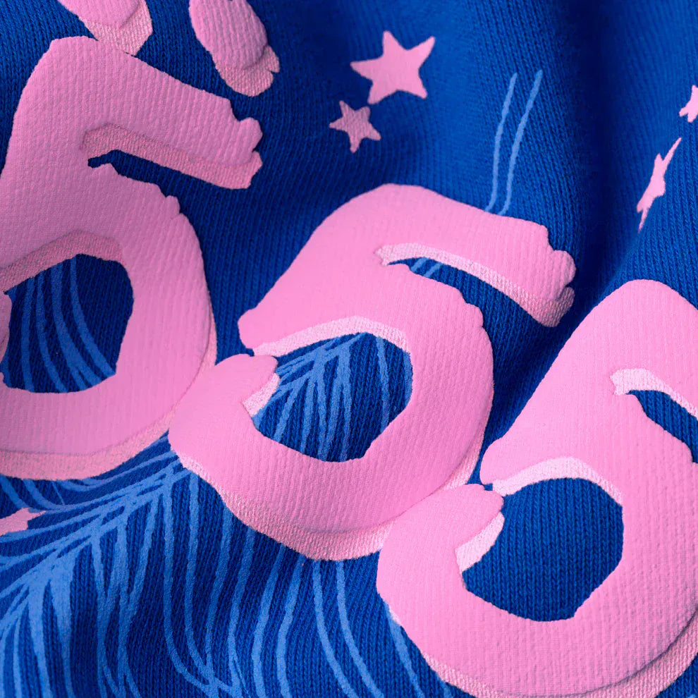 Close-up of royal blue 440GSM heavyweight fleece from the Sp5der “555” Hoodie, featuring bold pink numbers 555 and small stars, highlighting its signature spider web streetwear pullover style.