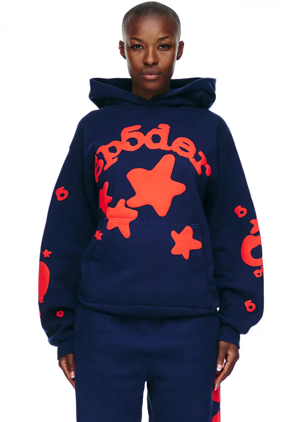 Model wears the Sp5der 440GSM Heavyweight Hoodie – Navy Blue with Red Star Puff Print Streetwear Pullover and matching navy pants, channeling Y2K fashion against a white background.