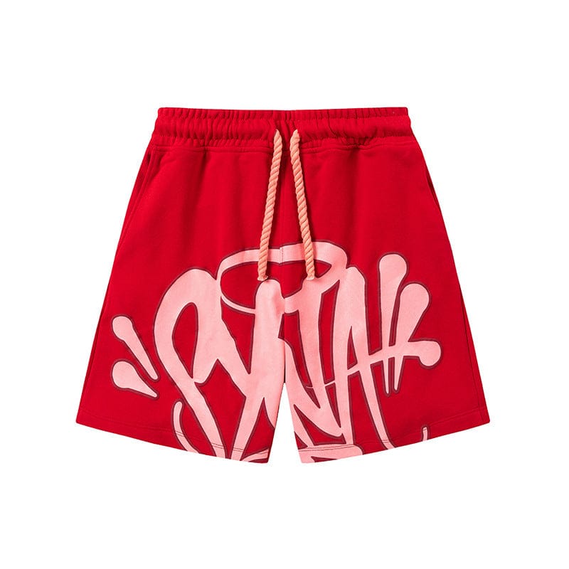 Syna World Graphic Shorts—streetwear drawstring shorts with a white graffiti-style print and beige rope waist, shown in red against a white background. Available in 8 colors.