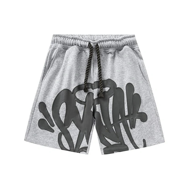 The Syna World Grey Graffiti Graphic Print Sweat Shorts feature bold black graffiti-style lettering on the front, a black drawstring, and are displayed on a white background.