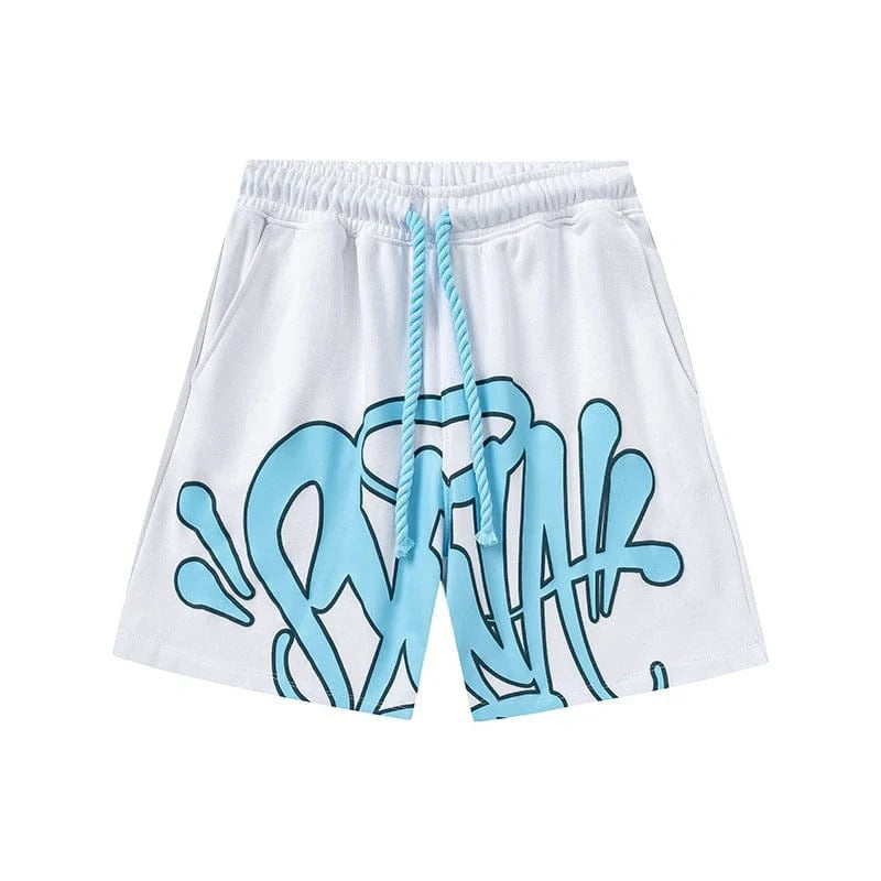 Syna World White Blue Graffiti Graphic Print Shorts feature an elastic waistband, blue drawstring, and bold graffiti logo with splashes, shown on a plain white background.
