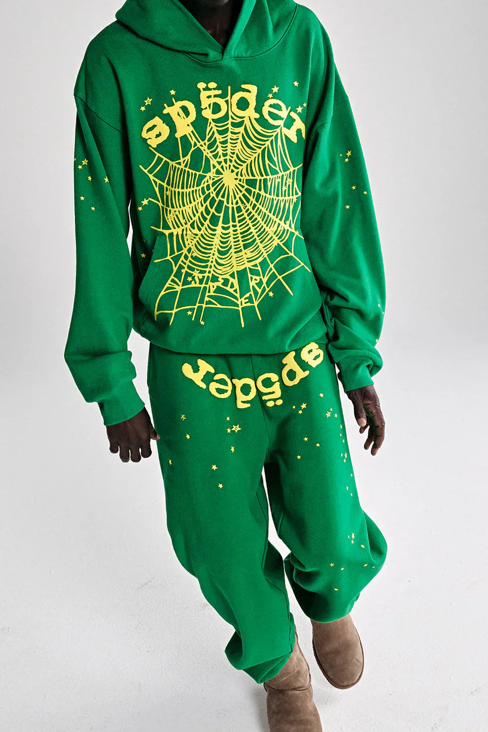 Model wears the Sp5der Web Hoodie – Emerald Green & Yellow 440GSM Heavyweight Oversized Streetwear Pullover, featuring bold yellow spiderweb and Sp5der text designs, styled against a white background.