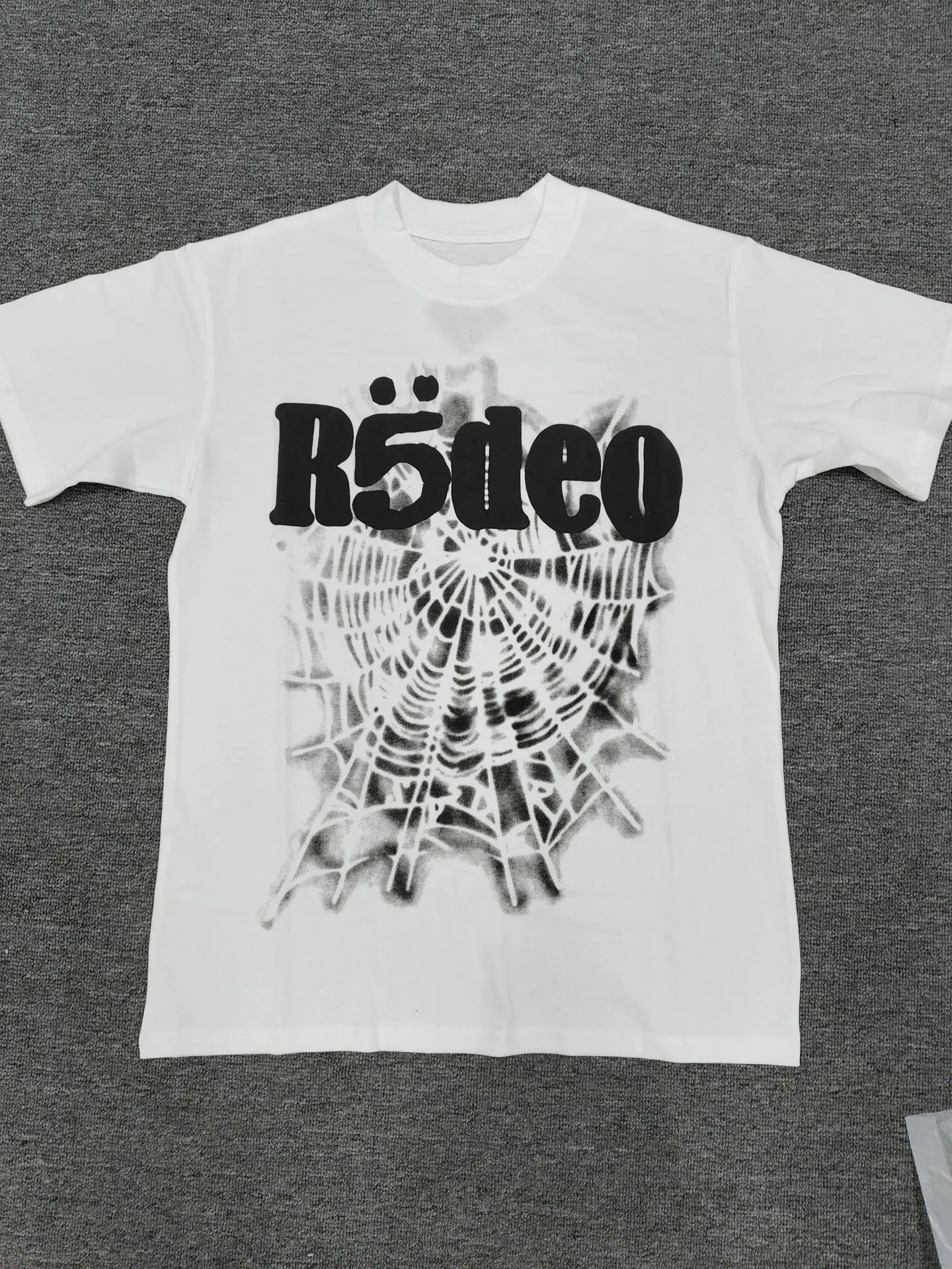 White Sp5der Rodeo spider web graphic short sleeve t-shirt laid flat