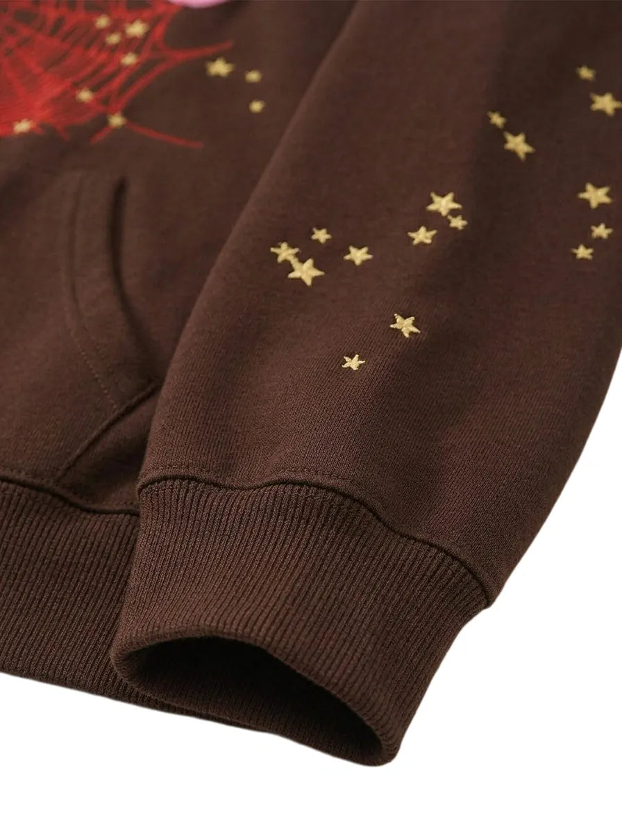 The 555 Brown Spider Hoodie is a heavyweight oversized pullover featuring yellow star patterns on the sleeve, a visible pocket seam, and comes in the Sp5der 555 Web Brown / Pink style at 440GSM.